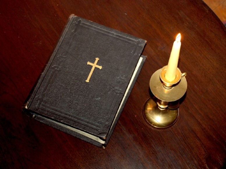 Holy Bible and Lit Candle